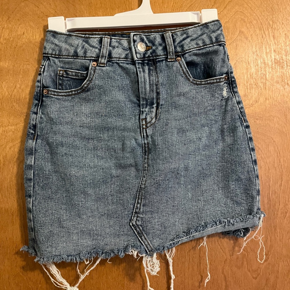 A jean skirt with tears at the bottom.